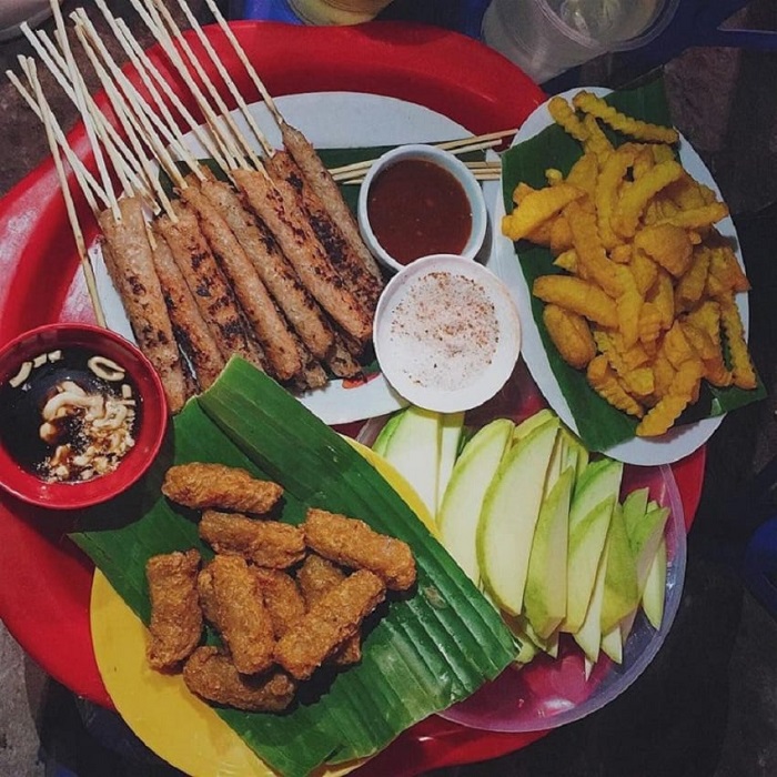 Un plateau d'en-cas vietnamiens dans la rue piétonne autour du lac Hoan Kiem: nem chua rán (rouleaux frits), brochettes de porc grillé, frites, mangue verte, sauce